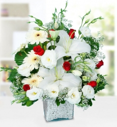 Beyaz Lilyum Gerbera ve Güller Kare cam vazo içerisinde kırmızı gül, beyaz lilyum, beyaz gerbera ve beyaz lisyantus ile hazırlanmıştır.